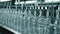 A row of glass vials on a conveyor belt