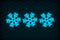 Row of glowing frozen snowflakes on dark wall. Neon effect. Large snowfalls in winter