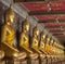 Row of golden seated buddhas in a Buddhist temple