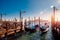Row of gondola boats parked outside restaurant Grand Canal in Venice, Italy.
