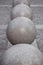 Row of granite balls on the pedestrian sidewalk paved with stone tiles.