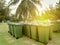 A row of green dustbin with sun flare.Pollution concept.