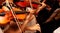 Row, group of anonymous violin players, children, people playing, bows in hands, stands in front, closeup. Classical music concert