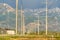 Row of high voltage electricity posts with rugged snowy mountain background