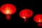 Row of illuminated chinese lanterns on dark background