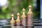 A row of increasing dollar coins on a chess board against a row of golden pawns