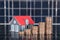 A row of increasing dollar coins and a small house model on a solar panel