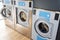 Row of industrial washing machines in a public Laundromat Dryers laundry