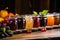 a row of jars with different fruit jams against a rustic background