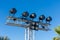 A row of large exterior spot lights on blue sky background for a sports competition, street festival or carnival at night