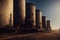 a row of large industrial tanks sitting next to each other on a road near a field of grass and trees