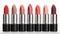 Row of lipstick in varying shades on white background