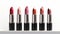 Row of lipstick in varying shades on white background