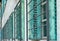 Row of many green window shutters and iron grates on a house front