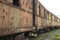 A row of many old rusty carriages fastened together