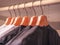 Row of men`s suits hanging in closet