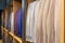 A row of men\\\'s suits, jackets hanging on a rack for display