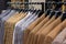 A row of men\\\'s suits, jackets hanging on a rack for display