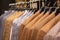 A row of men\\\'s suits, jackets hanging on a rack for display