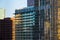 A row of modern glass and steel office and residential buildings reflecting the light of sunset in downtown Los Angeles