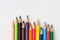 Row of multicolored rainbow palette pencils on white wood background. School art education kids creativity concept. Poster banner