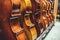 Row of multiple cellos standing on the floor at a musician workshop