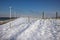 Row offshore windturbines along Ductch coast in winter with snow