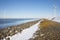 Row offshore windturbines along Ductch coast in winter with snow