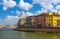 Row of old colorful buildings houses on embankment promenade of Arno river, Ponte Di Mezzo bridge in historical centre of Pisa