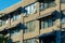 Row of open apartment or business windows in the downtown city late in afternoon sun with beige and brown stucco