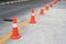 Row of orange rubber traffic cone placed in road