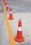 Row of orange rubber traffic cone placed in road