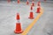 Row of orange rubber traffic cone placed in road