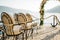 Row of padded chairs in front of a wedding arch on a cobbled pier