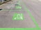 Row of painted signs on asphalt for parking and recharging of electric cars.