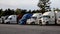 A row of parked semi trucks at a truck stop pan left