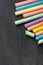Row Pile of Multicolored Chalks Crayons on Dark Scratched Blackboard. Back to School Business Creativity Graphic Design