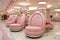 A row of pink chairs sitting in a room. Generative AI image.