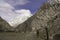 A row of pink cherry blossum trees with snow cap mountain of Passu Village