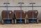 A row of pulling carts for baggage and children, locked and leashed on a metal bar, outdoor transportation