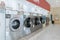 A row of qualified coin-operated washing machines in a public store.