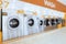 A row of qualified coin-operated washing machines in a public store.