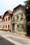 Row of renovated attached old suburban family houses with one abandoned ruin at the end of street with dilapidated walls