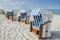 Row of roofed wicker beach chairs at baltic sea