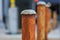 Row of rusty poles in city environment, shot with selective focus.