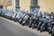 Row of scooters parked in a street of Florence Italy