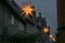 Row of shining Moravian stars between historic houses in the old town of Lubeck in Germany for advent and Christmas at night, copy