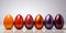 A row of shiny colored eggs sitting next to each other