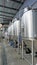 Row of shiny metal micro brewery tanks or Fermentation mash vats in Brewery factory