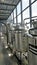 Row of shiny metal micro brewery tanks or Fermentation mash vats in Brewery factory